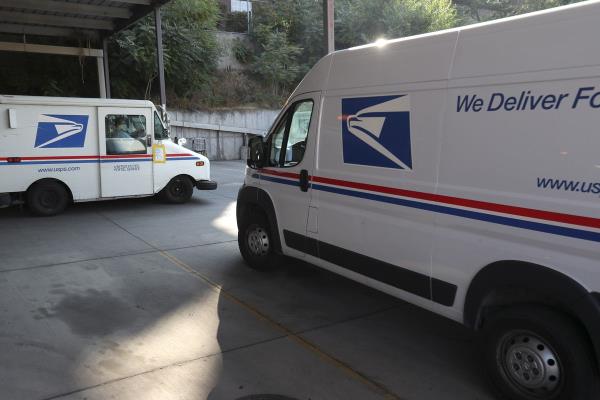 U.S. Postal Service letter carriers leave the post office in the Sugar House neighborhood of Salt Lake City on Oct. 7, 2020.