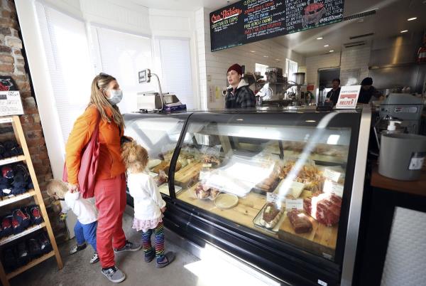 Caroline Laine shops with her children, Nico Laine and Alice Laine, as retail associate Ian Roth helps them at Beltex Meats in Salt Lake City on Friday, Feb. 4, 2022.