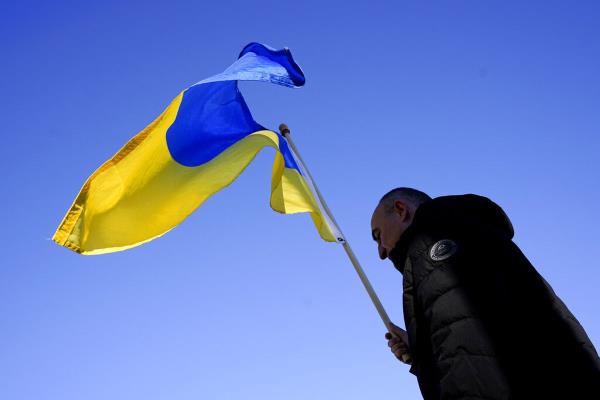 A man carries the Ukrainian natio<em></em>nal flag.