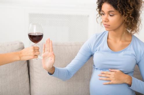pregnant woman refusing glass of wine