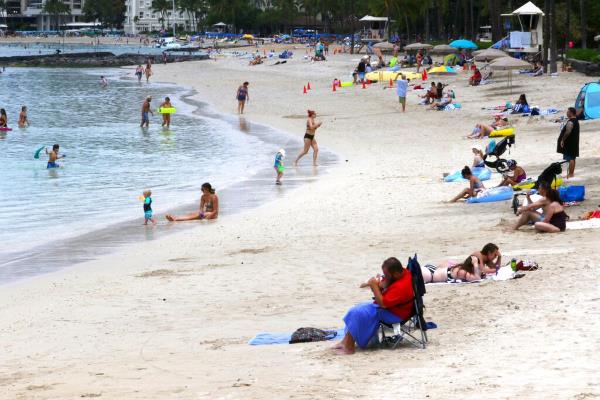 People sit on Waikiki Beach in Honolulu.